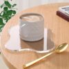 Clear irregular acrylic mirror coasters on modern coffee table