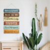 Room Flowy rustic motivational quote sign hanging in farmhouse living room with warm teal and brown tones